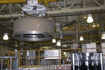 The outer-shell lid of a TRUPACT-II is lifted off inside of the Waste Handling Building.
